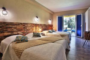卡拉罗莎杜邦德洛索酒店的带三张床和砖墙的房间