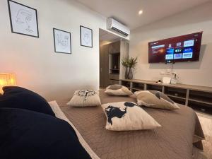 普拉亚卡门Syrena Luxury Caribbean的卧室配有2个枕头和1张床铺,提供平面电视