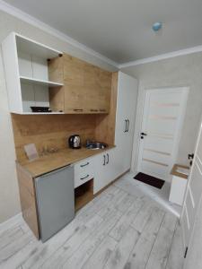 比什凯克Pravda的厨房铺有木地板,配有白色橱柜。