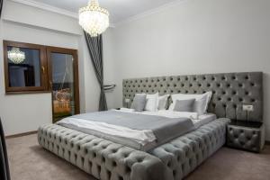 锡纳亚Chalet jolie Luxury Vila Sinaia的一间卧室配有一张大床和大床头板