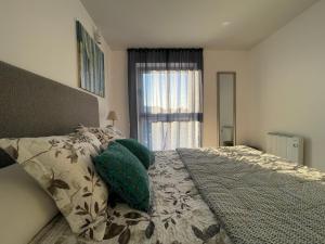 巴伦西亚Retiro em Valença的一间卧室配有一张带绿色枕头的床和一扇窗户