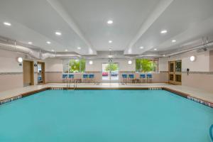 林赛林赛戴斯套房酒店 的一个带蓝色椅子的房间的游泳池