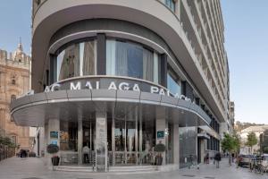 马拉加AC Hotel Málaga Palacio by Marriott的一座大建筑,上面有读马拉加公园的标志