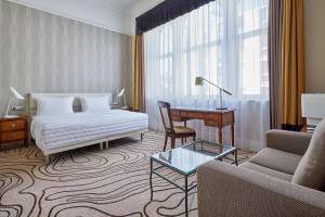 美因河畔法兰克福法兰克福艾美度假酒店的酒店客房配有床、沙发和桌子。