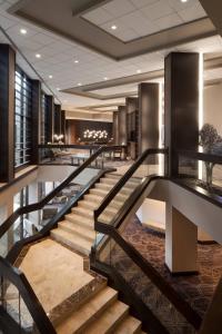 欧文Dallas/Fort Worth Airport Marriott的酒店大堂设有楼梯和桌子