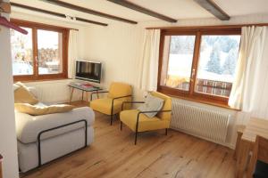 安特瓦塞尔Ferienhaus Oberguet的客厅配有沙发、两把椅子和电视