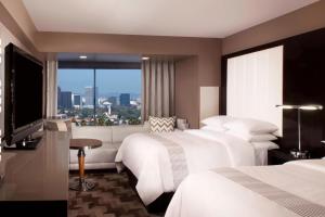 洛杉矶贝弗利山万豪酒店的酒店客房设有三张床和大窗户