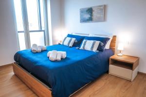 巴里JLH Aparts - Just Like Home的一间卧室配有蓝色的床和毛巾
