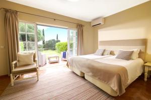 维拉摩拉Cegonha Country Club的一间卧室设有两张床和大窗户