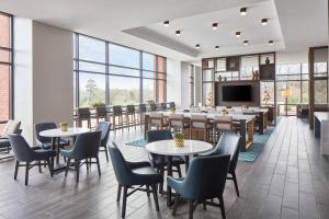 夏洛特UNC Charlotte Marriott Hotel & Conference Center的餐厅设有桌椅和平面电视。