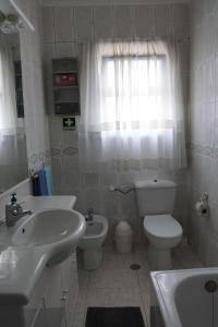 DamaiaHerois Apartment的白色的浴室设有水槽和卫生间。