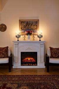 布拉格FLEUR DE LIS HOTEL的客厅设有壁炉,配有两把椅子和蜡烛