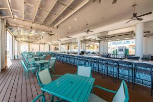 南帕诸岛Courtyard South Padre Island的一间设有蓝色桌椅的自助餐厅和一间酒吧
