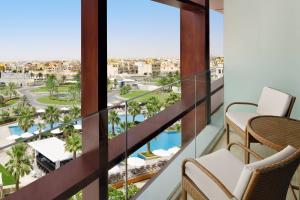 阿布扎比阿布扎比艾尔胡瑟万豪酒店的享有游泳池和棕榈树景致的阳台