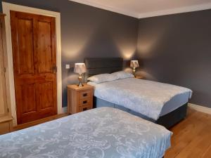 康镇Whitethorn Lodge, Bed & Breakfast, Lackafinna的一间卧室设有两张床和木门