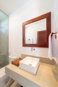 佩德拉斯港Pousada Praia do Patacho的浴室设有白色水槽和镜子