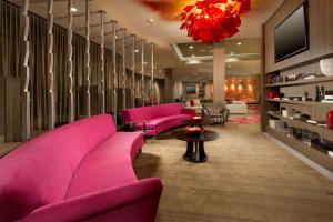 格雷普韦恩达拉斯-沃斯堡机场北/格雷普韦恩万怡酒店的客厅配有粉色家具和吊灯。