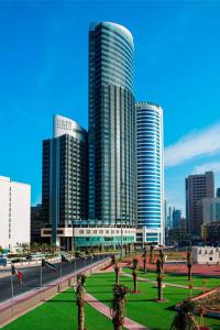 科威特福朋喜来登酒店的一座拥有高楼建筑的城市和一个棕榈树公园