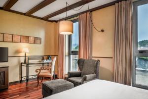 圣地亚哥－德孔波斯特拉卡门宫傲途格精选酒店的酒店客房,配有一张床、一张桌子和椅子