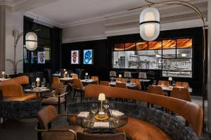 诺福克Glass Light Hotel & Gallery, Autograph Collection的一间带桌椅的餐厅和一间酒吧
