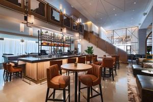 奥斯汀Austin Marriott Downtown的餐厅内的酒吧配有桌椅