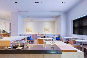 奥兰多奥兰多市中心喜来登酒店的餐厅设有桌椅和平面电视。