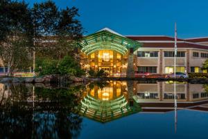 欧佩莱卡Auburn Marriott Opelika Resort & Spa at Grand National的一座晚上倒入水中的建筑