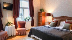 菲利普斯塔德尼格马赫斯庄园酒店的卧室配有床、椅子和窗户。