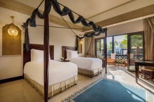 多哈Sharq Village & Spa, a Ritz-Carlton Hotel的一间带两张床的卧室和一个阳台