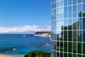 蒙特卡罗艾美度假酒店的水体旁的高玻璃建筑