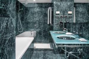 洛格罗尼奥拉丽娜万豪AC酒店的浴室配有水槽、淋浴和浴缸。