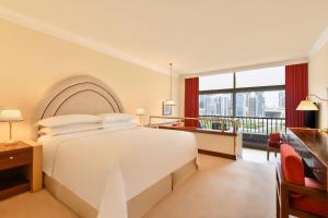 多哈喜来登超豪华度假会议酒店的卧室设有白色的床和大窗户