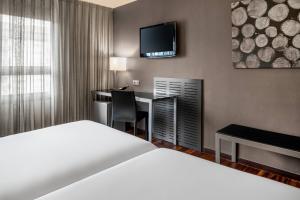 维多利亚-加斯特伊兹B&B HOTEL Vitoria General Álava的酒店客房设有一张床、一张书桌和一台电视机。