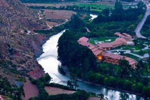 乌鲁班巴Tambo del Inka, a Luxury Collection Resort & Spa, Valle Sagrado的享有河流的空中景致,设有房屋