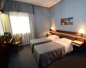 萨尔扎纳奥圣安德烈亚酒店的酒店客房设有两张床和窗户。