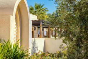 阿布扎比Al Wathba, a Luxury Collection Desert Resort & Spa, Abu Dhabi的一座带拱形窗户和树木的房子