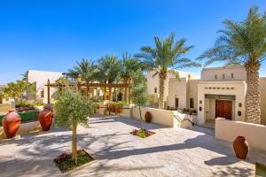 阿布扎比Al Wathba, a Luxury Collection Desert Resort & Spa, Abu Dhabi的棕榈树庭院和建筑