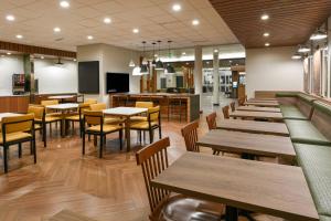 MoorparkFairfield Inn & Suites by Marriott Moorpark Ventura County的一间带木桌和椅子的餐厅和一间自助餐厅