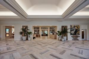 阿文图纳JW Marriott Miami Turnberry Resort & Spa的空荡荡荡的大堂,种植了盆栽植物,设有天花板