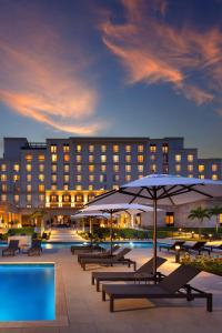 巴拿马城The Santa Maria, a Luxury Collection Hotel & Golf Resort, Panama City的配有桌子和遮阳伞的酒店和游泳池