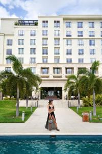 巴拿马城The Santa Maria, a Luxury Collection Hotel & Golf Resort, Panama City的女人在建筑物前摆姿势