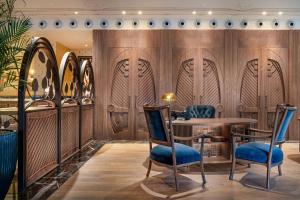 瓦伦西亚Palacio Santa Clara, Autograph Collection的餐厅拥有木墙和蓝色的椅子