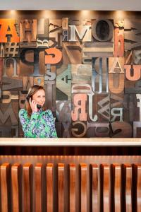 波特兰普莱斯酒店 - 傲途格精选酒店的墙上的女人用手机说话