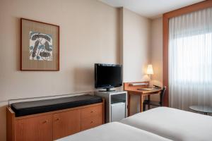 拉科鲁尼亚AC Hotel A Coruña by Marriott的配有一张床和一台平面电视的酒店客房