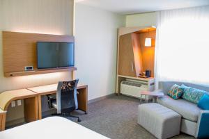 沃尔顿堡滩沃尔顿堡滩西德斯坦万怡酒店的酒店客房配有一张床、一张书桌和一张沙发。