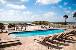 沃尔顿堡滩沃尔顿堡滩西德斯坦万怡酒店的一个带躺椅的游泳池和海滩