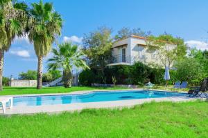 考瑙皮迪亚纳Villa Afroditi in Chania near Airport with Private Pool, Free Wi-Fi, Souda Bay Views, Garden Oasis的一座别墅,设有游泳池和棕榈树