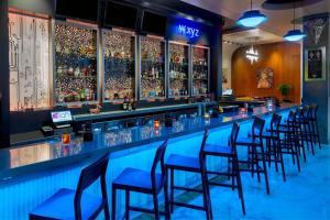 奥兰多奥兰多市中心雅乐轩酒店的一间酒吧,配有蓝色椅子和酒瓶