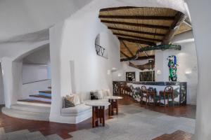 切尔沃港Hotel Cala di Volpe, a Luxury Collection Hotel, Costa Smeralda的客厅拥有白色的墙壁和木制天花板。