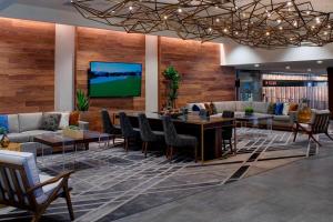 堪萨斯城堪萨斯城机场万豪酒店的大堂设有桌椅和电视。